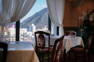 a dining room with a table and chairs and a window at Hotel Arthur KITAHAMA BASE in Beppu