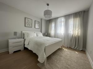 um quarto branco com uma cama e uma janela em Lavish 4BR House Near Simcoe Lake & FH Resort em Innisfil