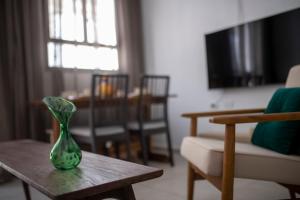a green vase sitting on a table in a living room at GOLANI8 in Haifa