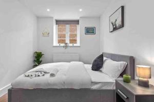 een slaapkamer met een bed, een bureau en een raam bij Cozy Flat near London Eye/ Victoria / Vauxhall in Londen