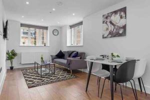een woonkamer met een tafel en een bank bij Cozy Flat near London Eye/ Victoria / Vauxhall in Londen