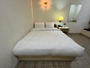 un grande letto bianco in una stanza d'albergo di 日日 Meworld a Beigang