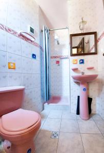 a bathroom with a pink toilet and a sink at Hotel El Super 8 in Cochabamba