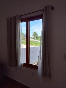 a window with white curtains in a room at Chalé Aconchego da Serra in Serra de São Bento