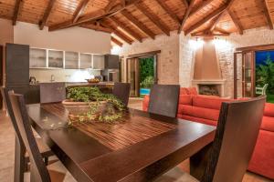 a kitchen and dining room with a table and a couch at Astarte Villas - Kyveli Luxurious Private Villa in Zakynthos