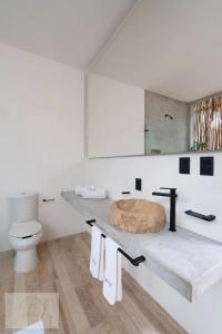 une salle de bain blanche avec un lavabo et des toilettes dans l'établissement Villa Toh, à Tulum 29 autres photos