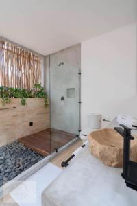 une salle de bain avec une douche en verre et des toilettes dans l'établissement Villa Toh, à Tulum