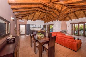 a living room with a table and a red couch at Astarte Villas - Kyveli Luxurious Private Villa in Zakynthos Town