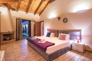Astarte Villas - Kyveli Luxurious Private Villa في مدينة زاكينثوس: غرفة نوم بسرير كبير ومدفأة