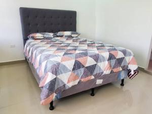uma cama com uma colcha num quarto em Apartamentos y Hostal Rudon # 5 em Puerto Cortes
