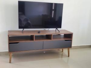 um centro de entretenimento em madeira com uma televisão de ecrã plano em Apartamentos y Hostal Rudon # 5 em Puerto Cortes