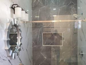 uma casa de banho com um chuveiro e uma parede em mármore preto em Apartamentos y Hostal Rudon # 5 em Puerto Cortes