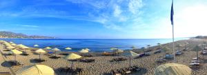 a beach area with umbrellas and chairs at Apollonia Beach Resort & Spa in Amoudara Herakliou