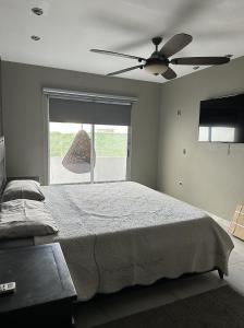 um quarto com uma cama, uma ventoinha de tecto e uma janela em Residencia en Apodaca Nuevo León em Monterrey