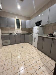 a kitchen with white appliances and a tiled floor at سمو سويت للشقق المخدومة 2 Smo Suites in Riyadh