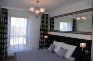 a bedroom with a bed and a large mirror at Apartamenty Adalbert in Gdańsk
