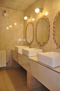 a bathroom with two sinks and two mirrors at Hostel Copacabana La Quiaca in La Quiaca