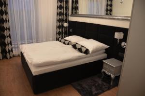 ein kleines Bett in einem Zimmer mit Spiegel in der Unterkunft Apartamenty Adalbert in Danzig
