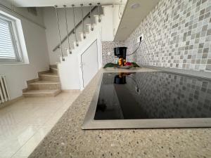 a kitchen with a counter and a tile wall at Villa Porthos in Hvar +83 photos