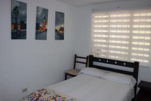 a bedroom with a bed and a window with a window shade at Panorama in Villavicencio