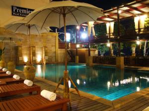 a swimming pool with an umbrella in a hotel at Sarita Chalet & Spa Hotel - SHA Extra Plus in Jomtien Beach