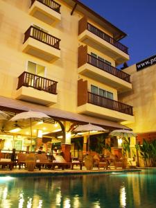 a hotel with a swimming pool in front of a building at Sarita Chalet & Spa Hotel - SHA Extra Plus in Jomtien Beach