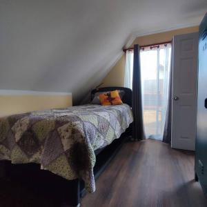 ein Schlafzimmer mit einem Bett und eine Treppe mit einem Fenster in der Unterkunft Acogedor departamento interior con acceso independiente y estacionamiento in La Serena