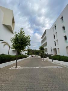 une rue pavée en face d'un bâtiment blanc dans l'établissement Cap Tingis, à Tanger