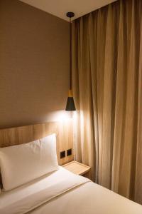 sypialnia z białym łóżkiem z lampką w obiekcie N Hotel w Tajpej