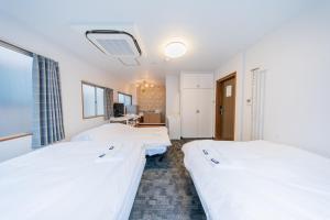 ein Krankenhauszimmer mit 2 Betten und einem TV in der Unterkunft Tokyo SA Ryokan in Tokio