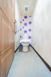 a bathroom with a toilet with purple flowers on the wall at Tokyo SA Ryokan in Tokyo