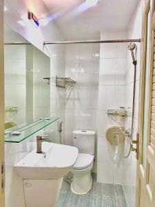 ホーチミン・シティにあるAlley Stay 39のトイレと洗面台を備えた白いバスルーム