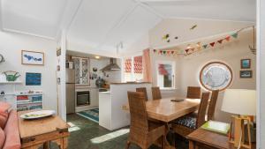 a kitchen and dining room with a table and chairs at Beachside Bliss - Waiwera Beachfront Holiday Home in Orewa