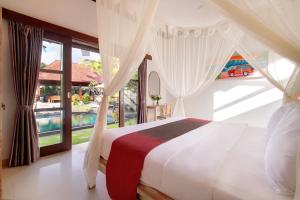 een slaapkamer met een bed en een groot raam bij Kandahill Bali in Uluwatu +37 foto's