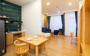 cocina y sala de estar con mesa y sillas en Vy's House Phanthiet Hotel, en Ấp Tân An (1)