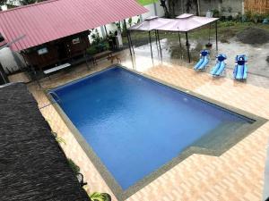 una gran piscina de agua azul en un patio trasero en Rainiers Private Resort House with 2 rooms 