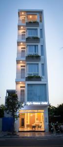 un edificio alto y blanco con una mesa delante en Vy's House Phanthiet Hotel, en Ấp Tân An (1)