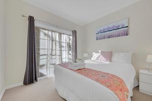 a white bedroom with a large bed and a window at 406 Back Porepunkah Road, Bright in Bright