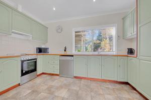 a large kitchen with white cabinets and a window at 406 Back Porepunkah Road, Bright in Bright