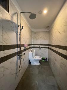 a bathroom with a toilet and a shower in it at Kenpi Homestay in Hue