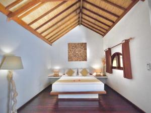 Un dormitorio con dos camas y techo de madera. en Laguna Gili, en Gili Trawangan