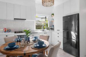 a kitchen with a wooden table and a refrigerator at Dicky Beach Original - 2 Bed Downstairs Studio 200m to Beach in Caloundra