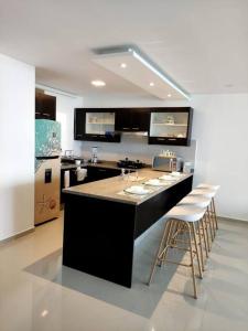a kitchen with a large island with bar stools at Departamento Playero Fountaine Bleau Frente al Mar Tonsupa in Tonsupa