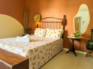 a bedroom with a large bed with a mirror at Casa das Lunas in Praia do Forte
