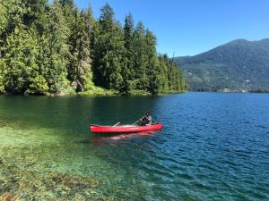 a person in a red canoe on a lake at Ruby Lake Resort in Madeira Park