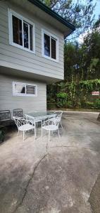 a table and two chairs in front of a house at JCGA Apartments (Angelo's Burnham) in Baguio