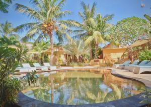 una piscina en el patio trasero de una casa con palmeras en Laguna Gili, en Gili Trawangan