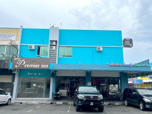 a blue building with cars parked in a parking lot at Hotel Premier Inn (Prima Square) in Sandakan