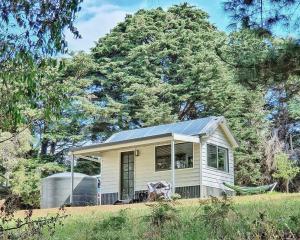una pequeña casa con un panel solar. en Mornington Peninsula Tiny House - Tiny Stays, en Red Hill