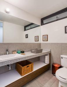 a bathroom with a sink and a toilet and a mirror at Unique Roma Apartments S51 By MrW in Mexico City